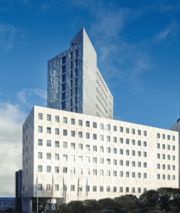 A large white building with a tall tower in the background.