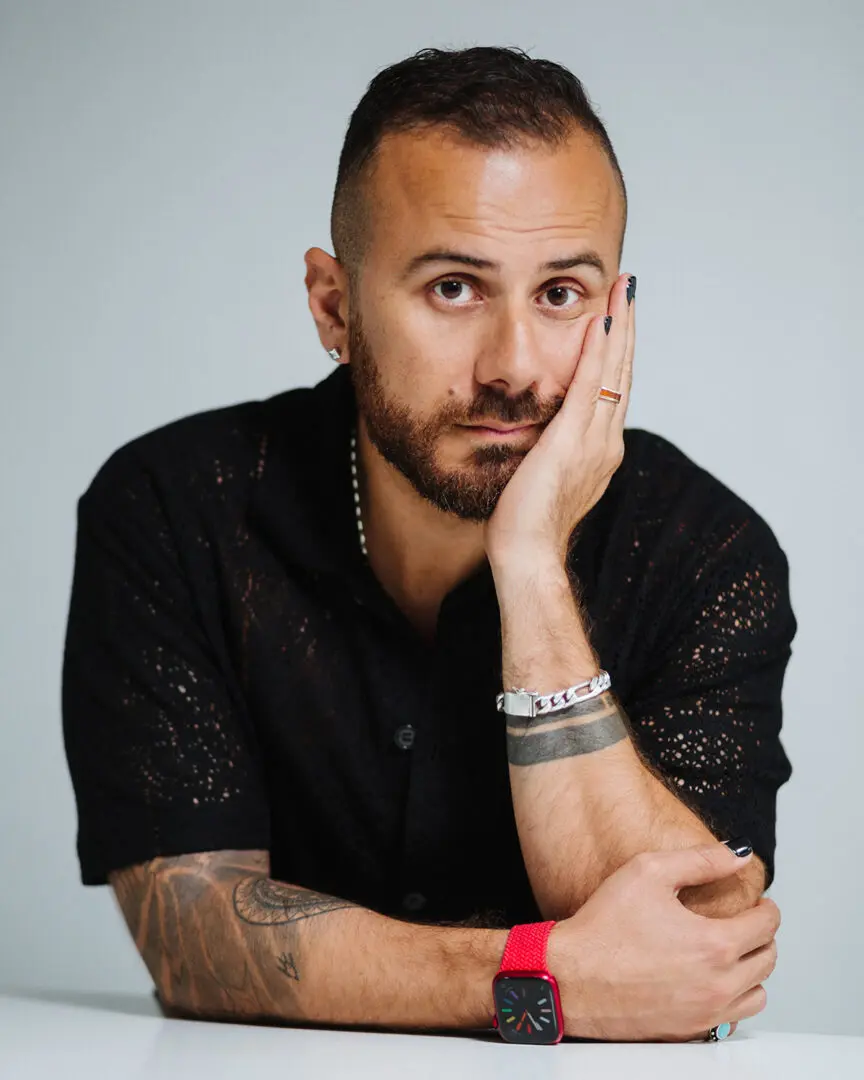 Portrait of a man with tattoos and a watch.