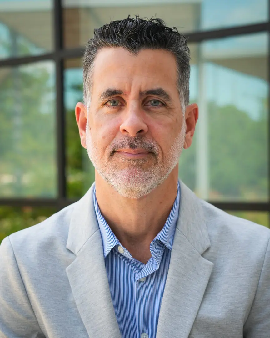 Headshot of a man in a gray blazer.